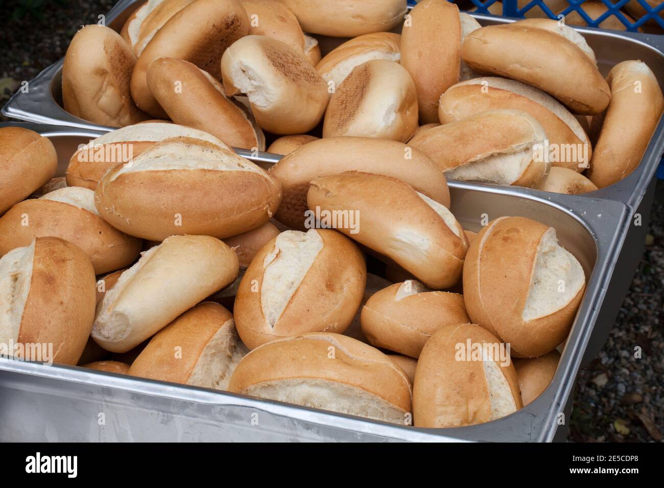 Many crusty bread rolls in a metal container for sale Stock Photo