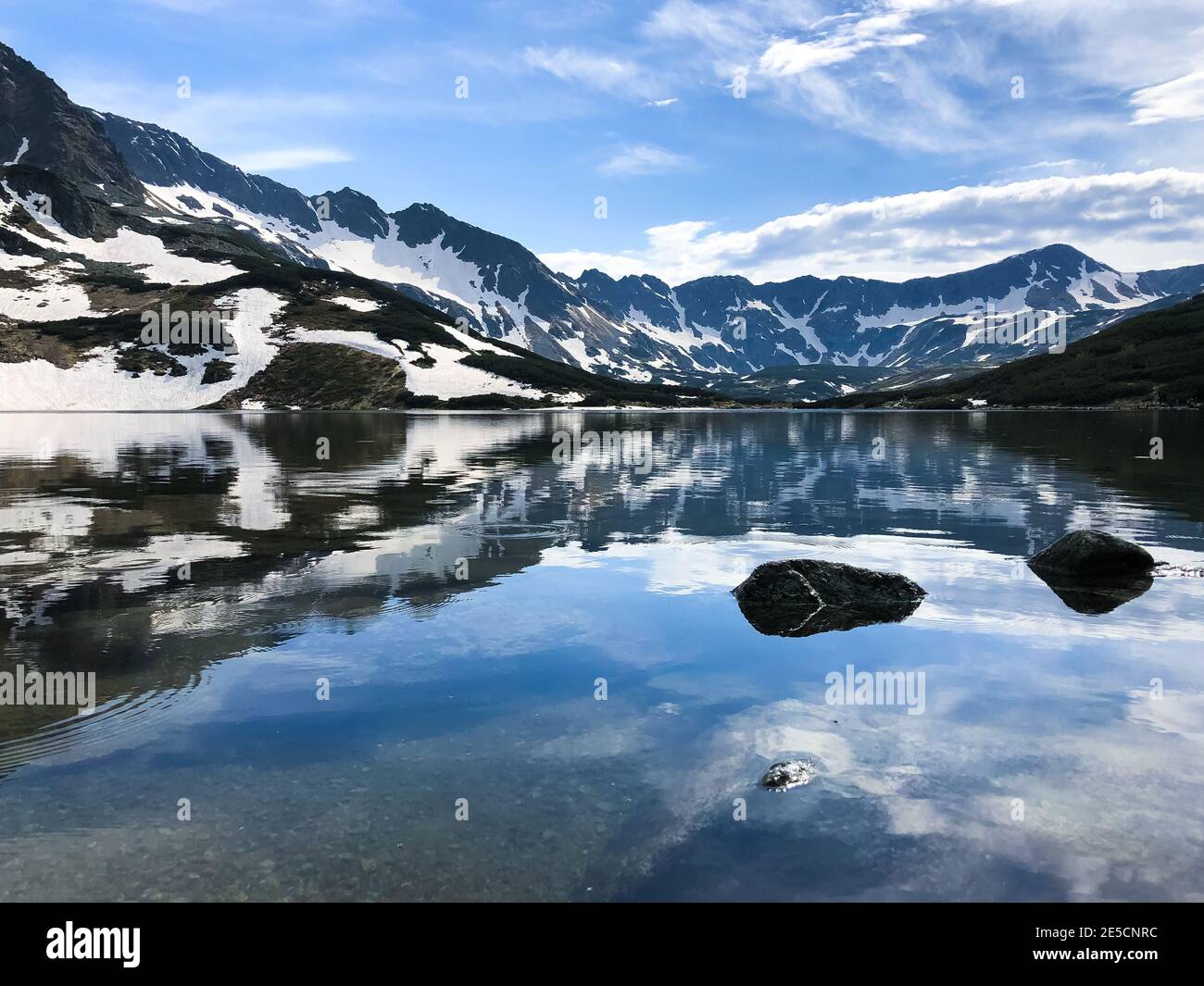 Snow-covered mountains reflecting in the water, Five Polish Ponds ...