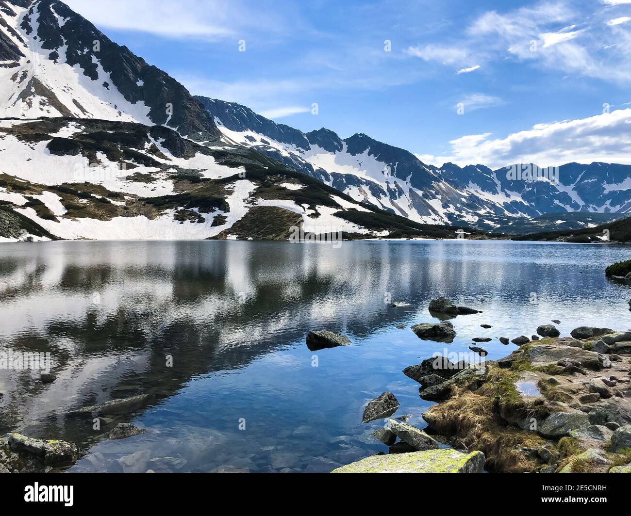Beautiful winter mountainscape reflecting in the water, Five Polish Ponds Valley Stock Photo