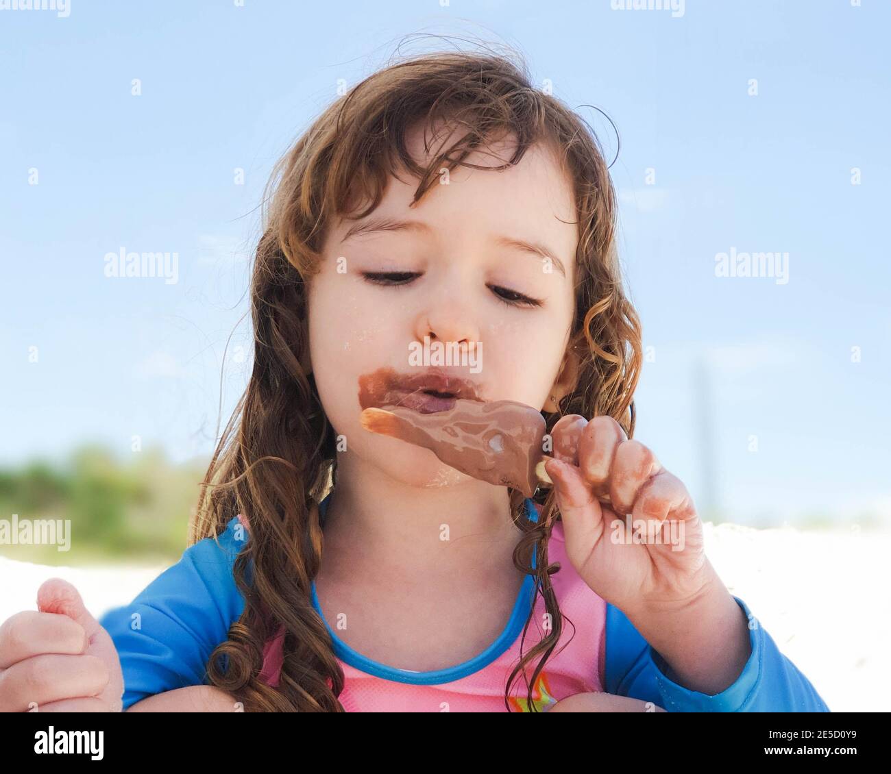 Portrait of a girl on the beach eating a chocolate ice lolly, Rio de Janeiro, Brazil Stock Photo