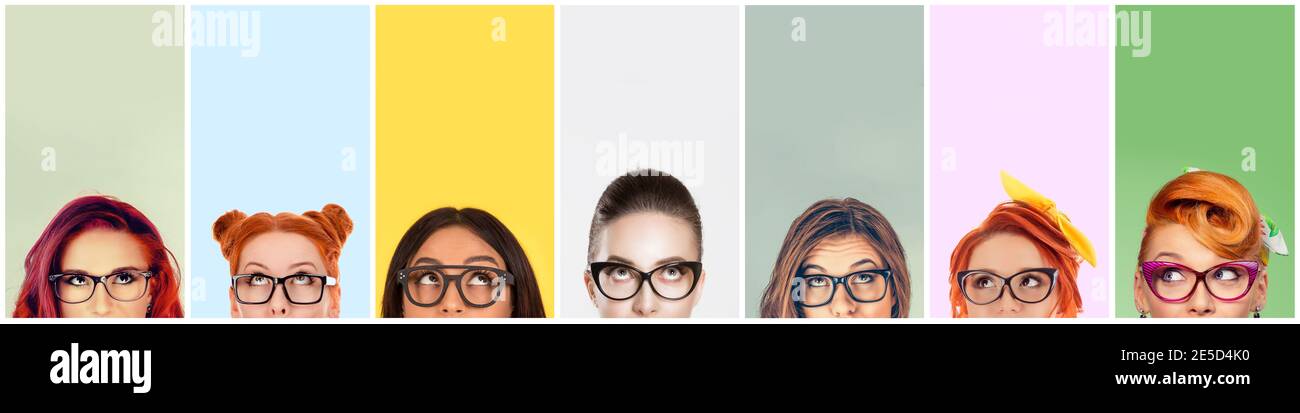 closeup portrait headshot cropped faces above lips of funny women in glasses looking up isolated on colorful studio wall background with copy space ab Stock Photo