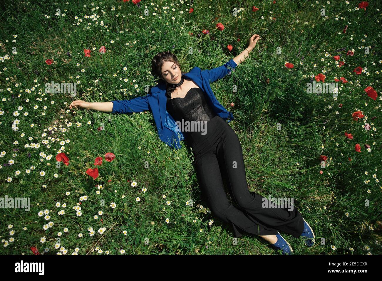Overhead view of a young woman lying in a meadow of wildflowers, Bulgaria Stock Photo