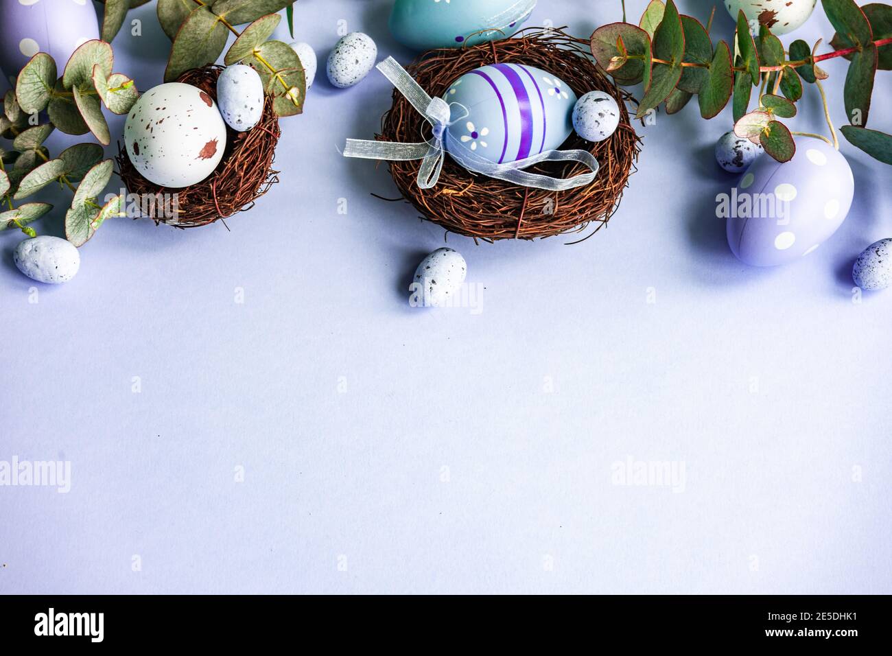 Easter eggs in bird's nests with eucalyptus stems Stock Photo