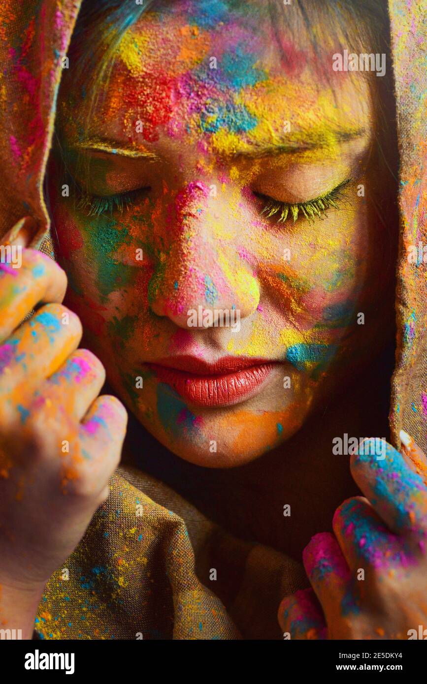 Portrait of a Woman covered in multi coloured powder during Holi festival Stock Photo