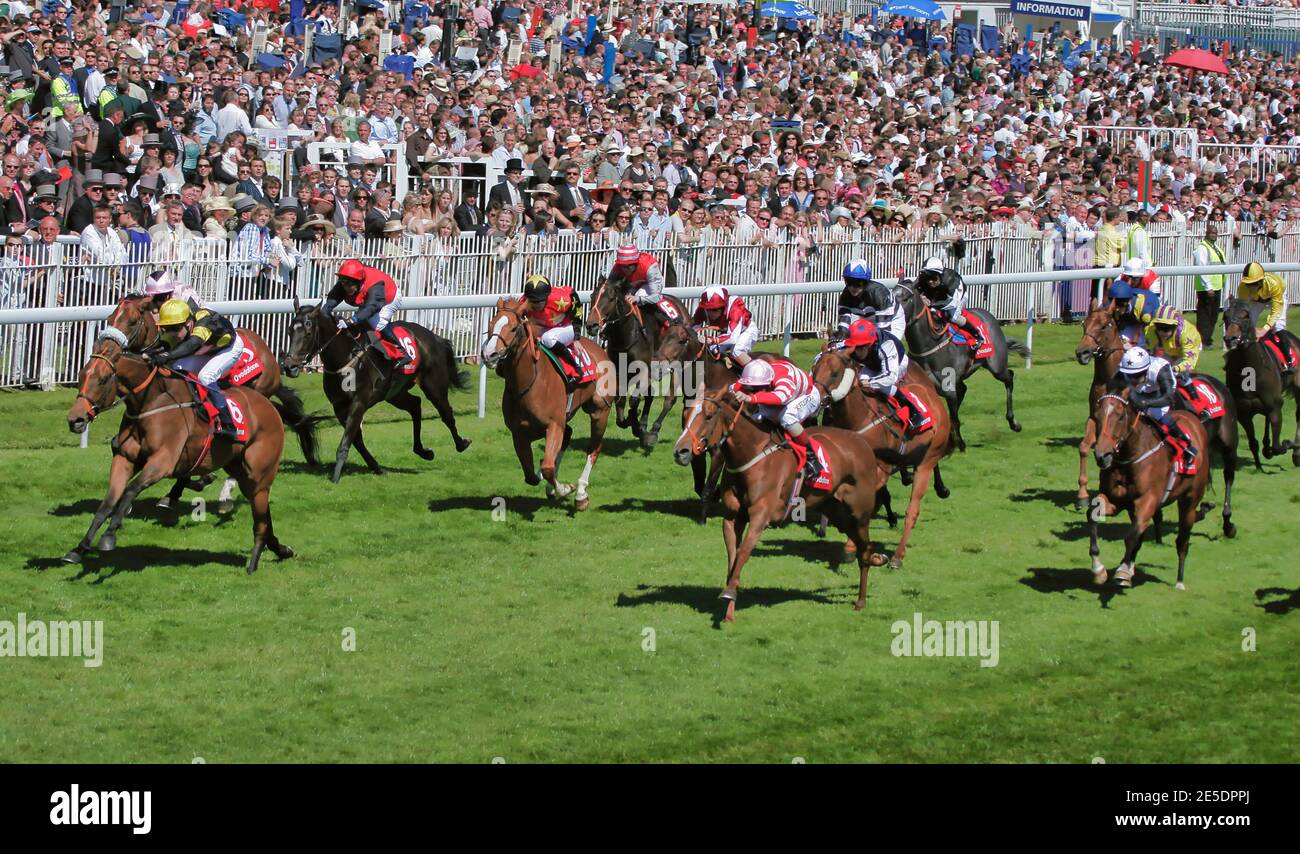 Huge crowds line the finish straight during a 'cavalry charge' finish of horse racing at Epsom Downs in Surrey UK Stock Photo