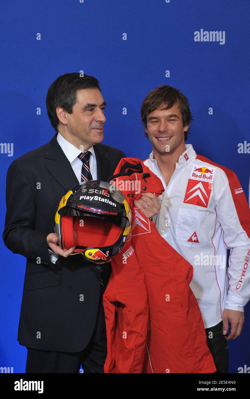 French Prime minister Francois Fillon (L) wears a rally auto helmet