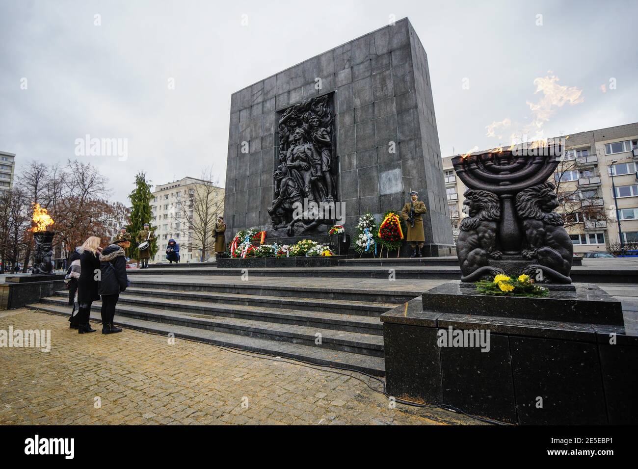 Warsaw, Poland. 27th Jan, 2021. People pay their respects to the victims of the Holocaust at the Ghetto Heroes Monument in Warsaw, Poland, on Jan. 27, 2021. Amid the ongoing COVID-19 pandemic, Poland commemorated the International Holocaust Remembrance Day on Wednesday almost fully online, with limited live events including honor guards and wreath-laying at various monuments throughout the country. Credit: Jaap Arriens/Xinhua/Alamy Live News Stock Photo