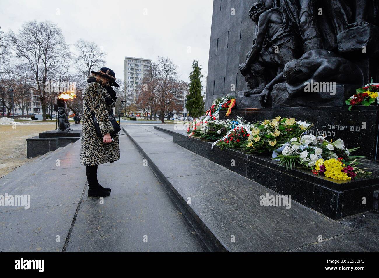 Warsaw, Poland. 27th Jan, 2021. A woman pays her respects to the victims of the Holocaust at the Ghetto Heroes Monument in Warsaw, Poland, on Jan. 27, 2021. Amid the ongoing COVID-19 pandemic, Poland commemorated the International Holocaust Remembrance Day on Wednesday almost fully online, with limited live events including honor guards and wreath-laying at various monuments throughout the country. Credit: Jaap Arriens/Xinhua/Alamy Live News Stock Photo