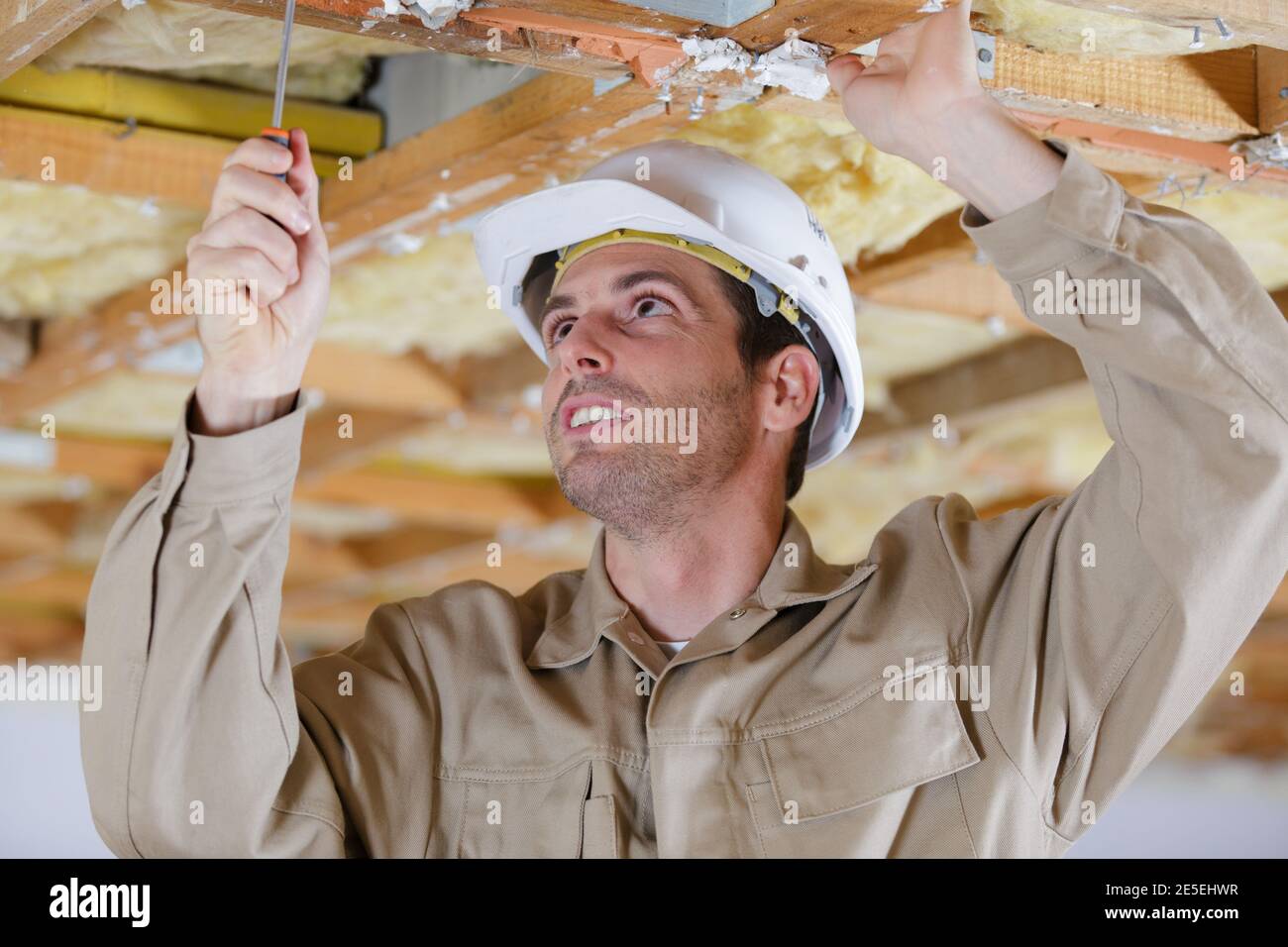 man in builder uniform installing suspended ceiling Stock Photo - Alamy