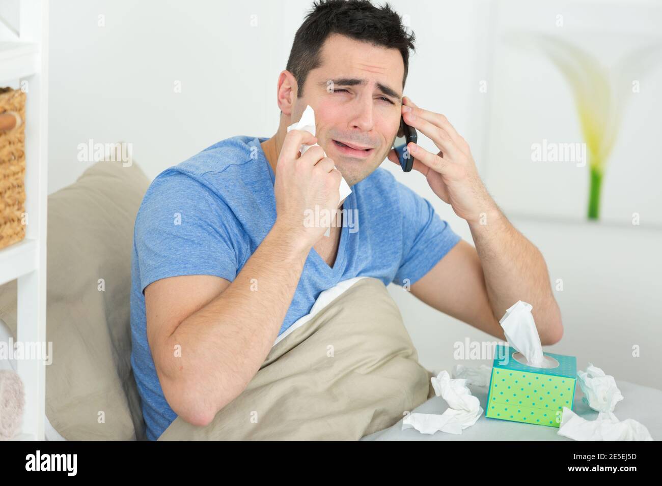 young desperate man lying on bed alone sad Stock Photo