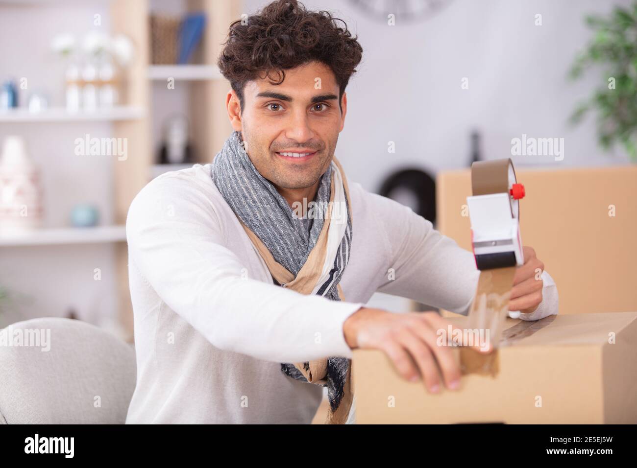 man sealing cardboard box with adhesive tape Stock Photo Alamy