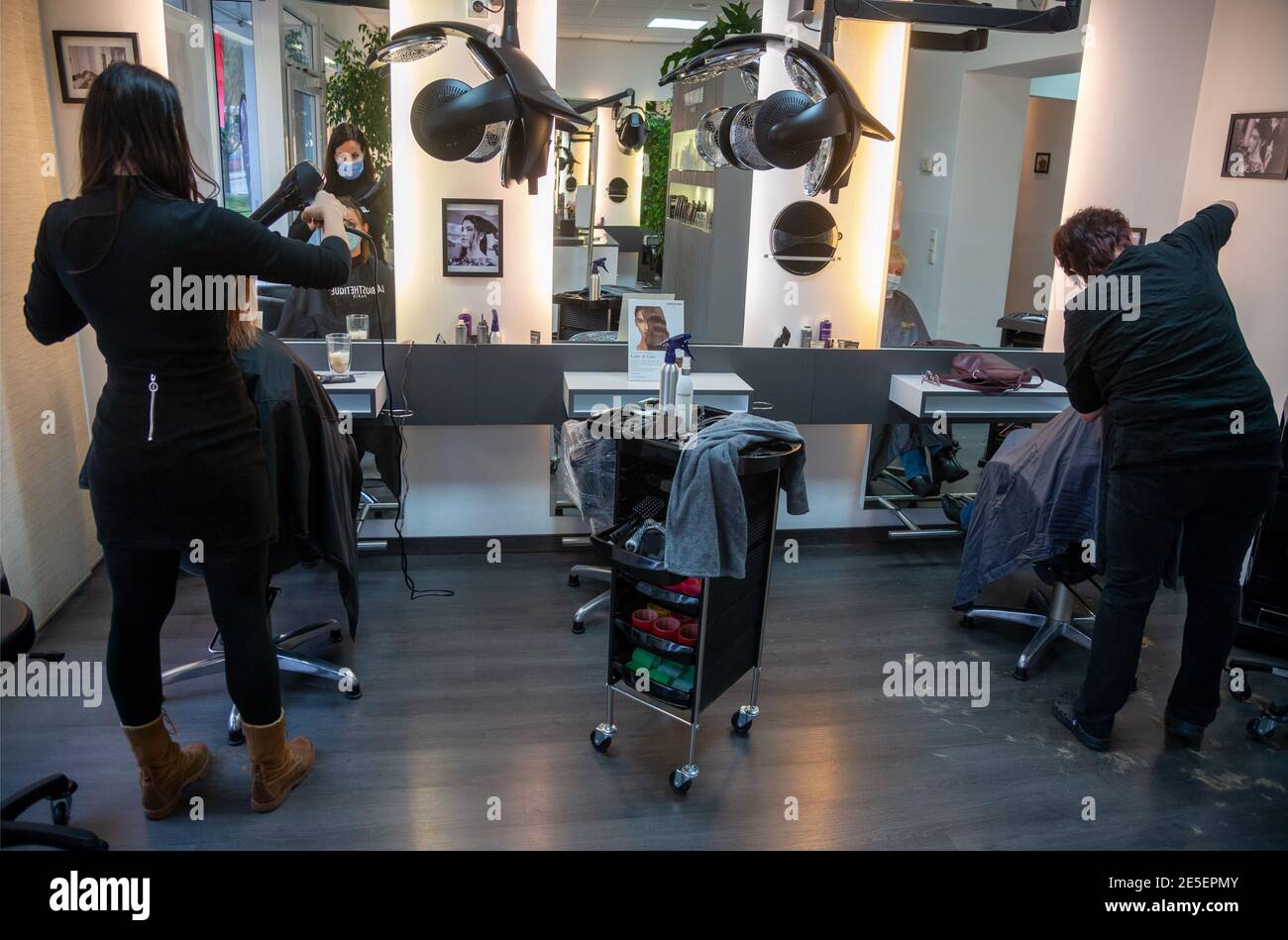 Wasserbillig, Luxembourg. 27th Jan, 2021. Hairdresser Christina Helmling (l) and employee Uli