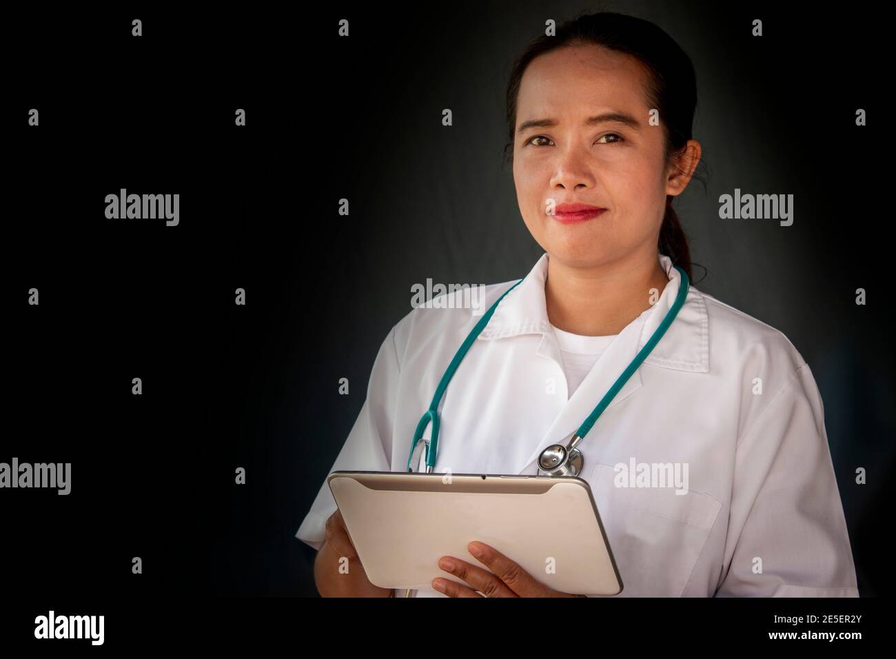 Portrait of female doctor in white coat with stethoscope and tablet ...