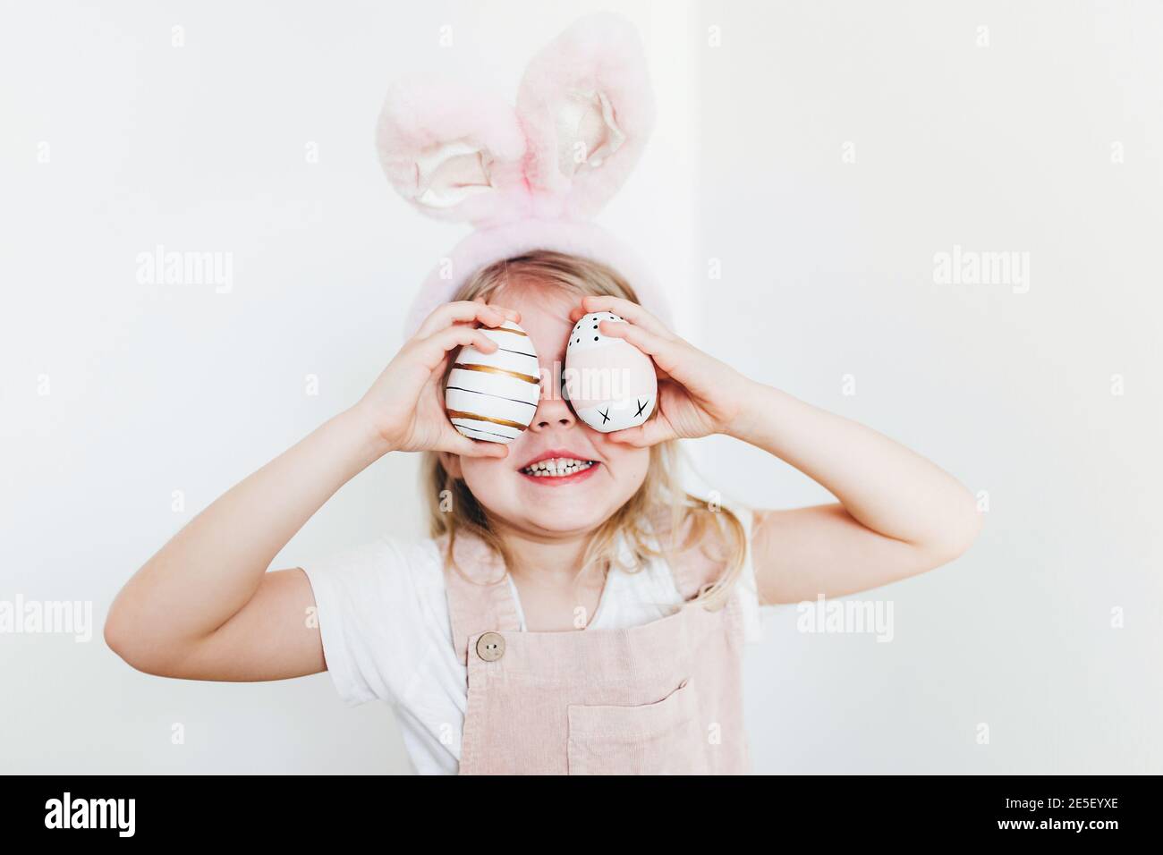 Little girl with Easter eggs and bunny ears hat Stock Photo