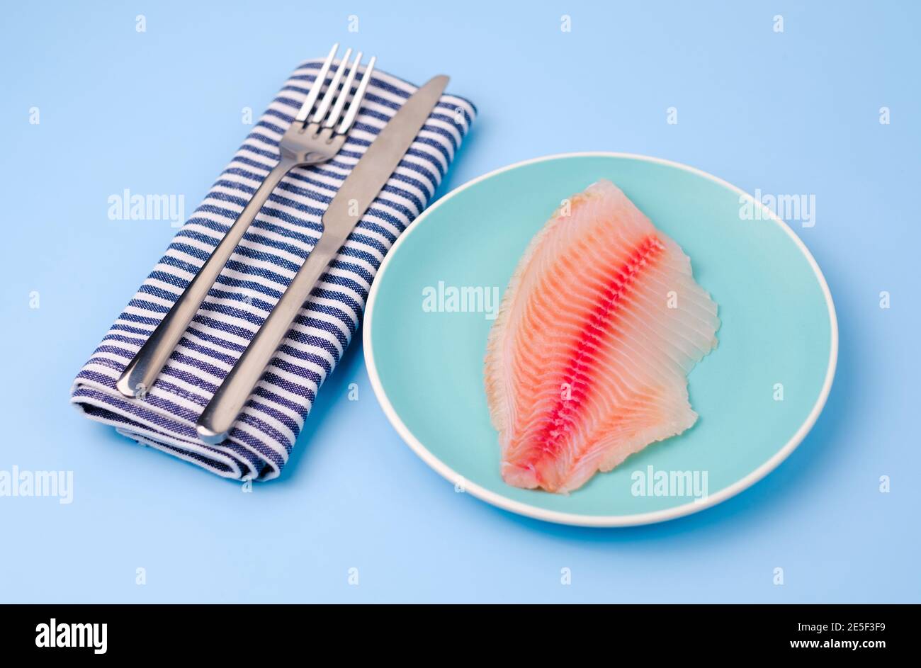 Uncooked fish on white plate hi-res stock photography and images