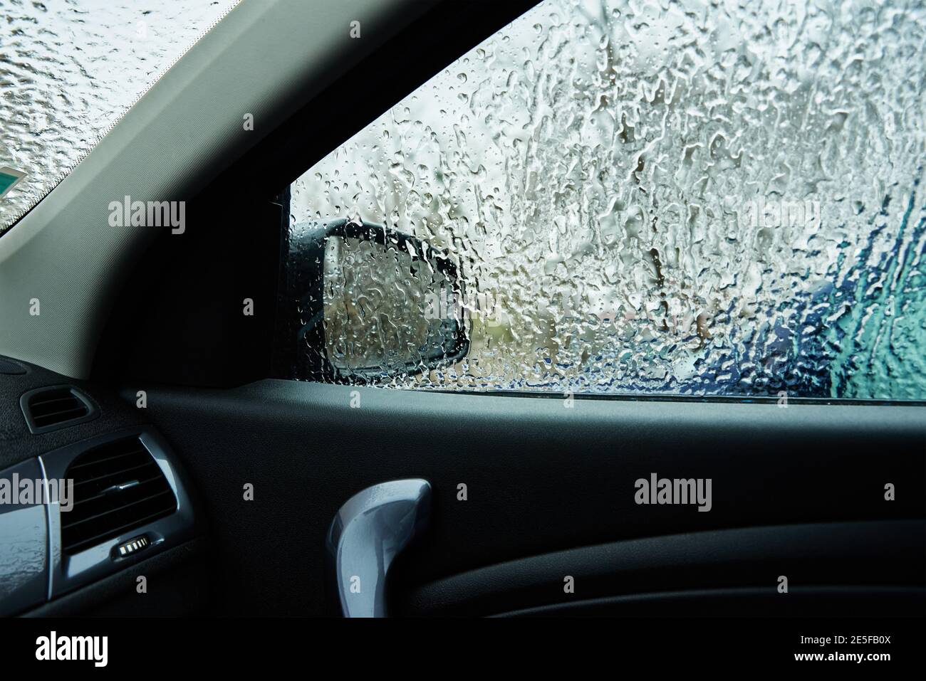 Inside view from car covered in freezing rain. Ice on a car windshield