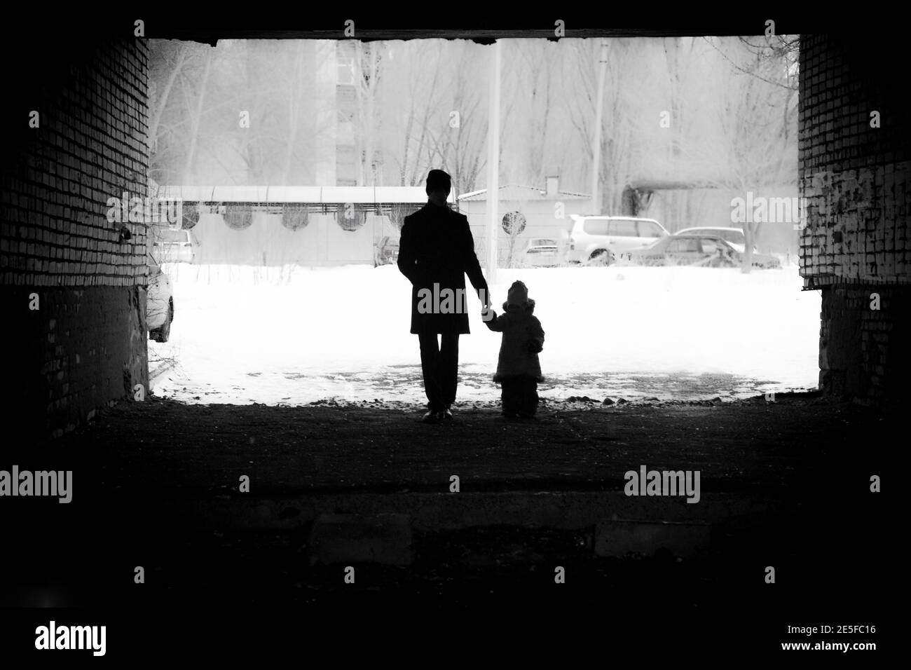 a man holds the hand of a girl winter background silhouette Stock Photo