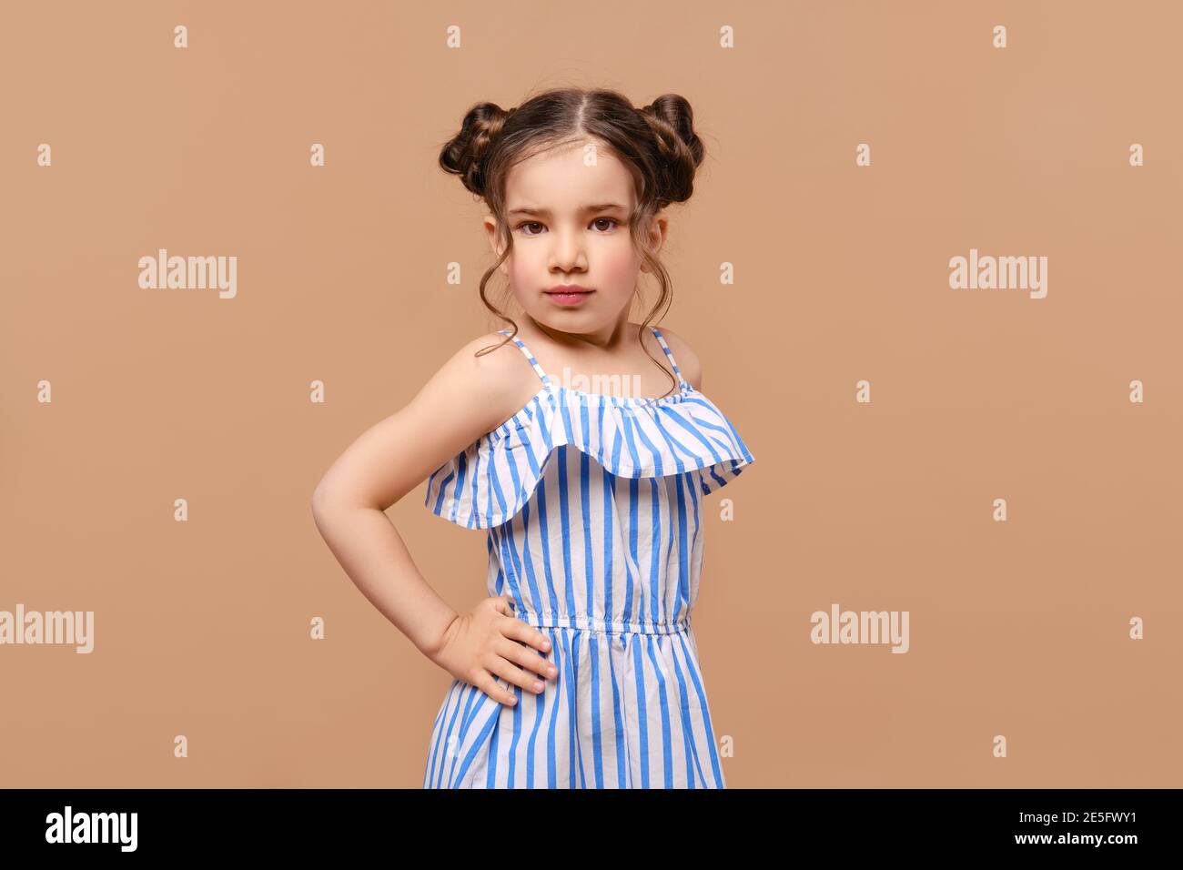 Portrait of cute young girl in sundress posing in studio Stock Photo