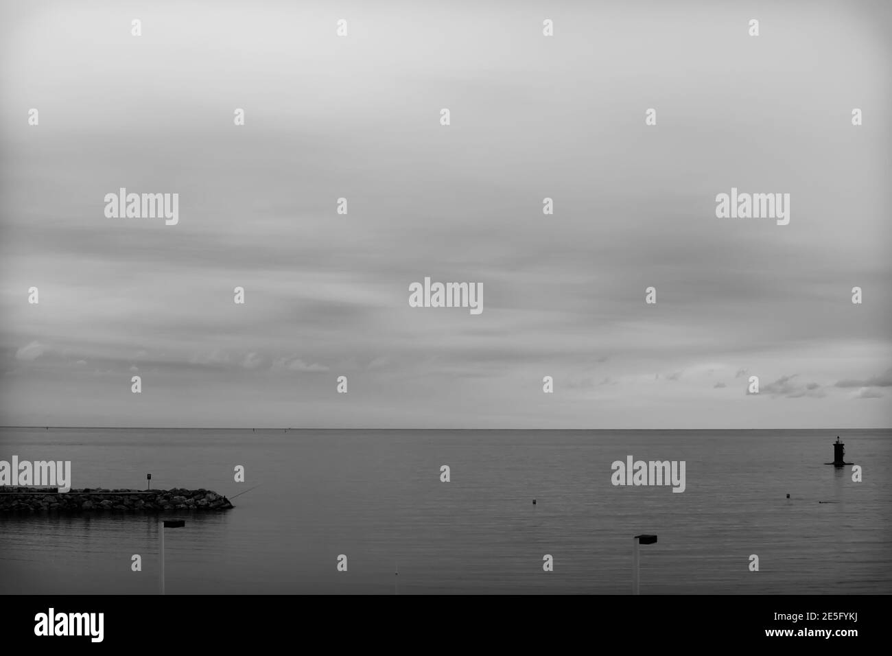 Minimalist landscape of the quiet beach of Gijón, Asturias, Spain.The photo is in black and white and aims to convey tranquility and calm. Stock Photo