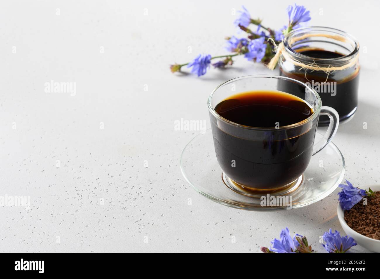 Chicory root coffee in glass cup and fresh flowers. Health Benefits
