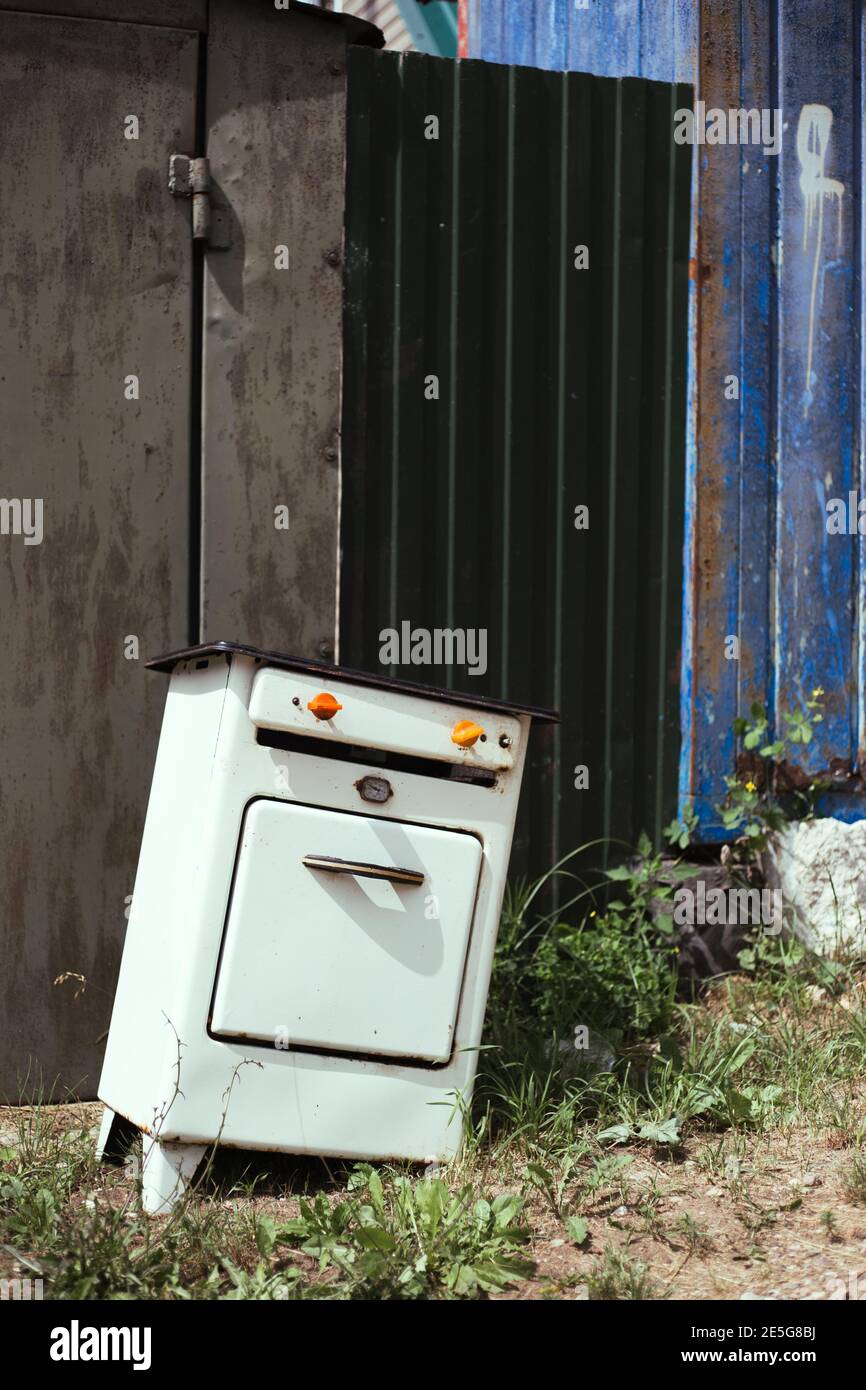 An old white gas stove lies near the fence Stock Photo Alamy