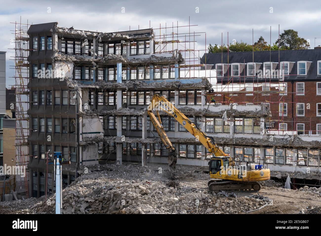 Demolition site high view (rubble, heavy machinery, excavator working & demolishing empty office building shell) - Hudson House, York, England, UK. Stock Photo