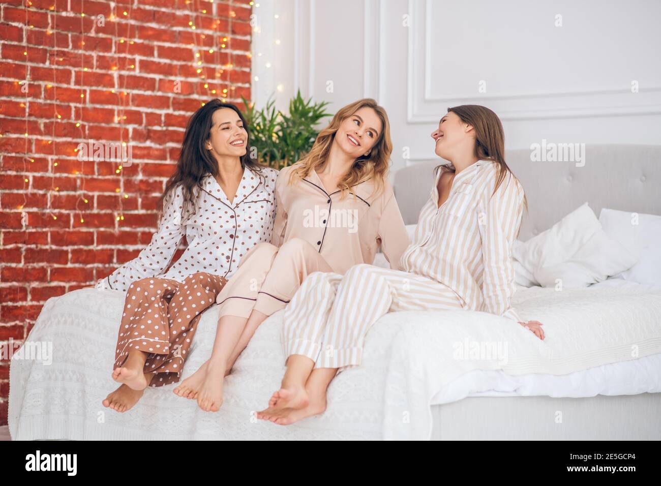 Three cute girls spending time together while having pajama party Stock Photo
