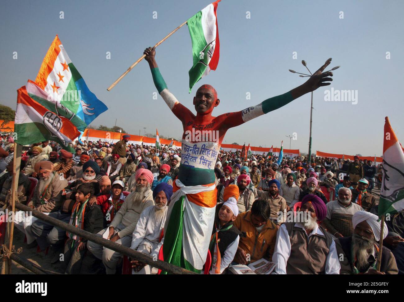 A supporter of India's ruling Congress party waves a flag during a campaign rally by Rahul Gandhi, a lawmaker and son of Congress party chief Sonia Gandhi, ahead of state assembly elections at Sirhind in the northern Indian state of Punjab January 27, 2012.  REUTERS/Ajay Verma (INDIA - Tags: ELECTIONS POLITICS TPX IMAGES OF THE DAY) Stock Photo