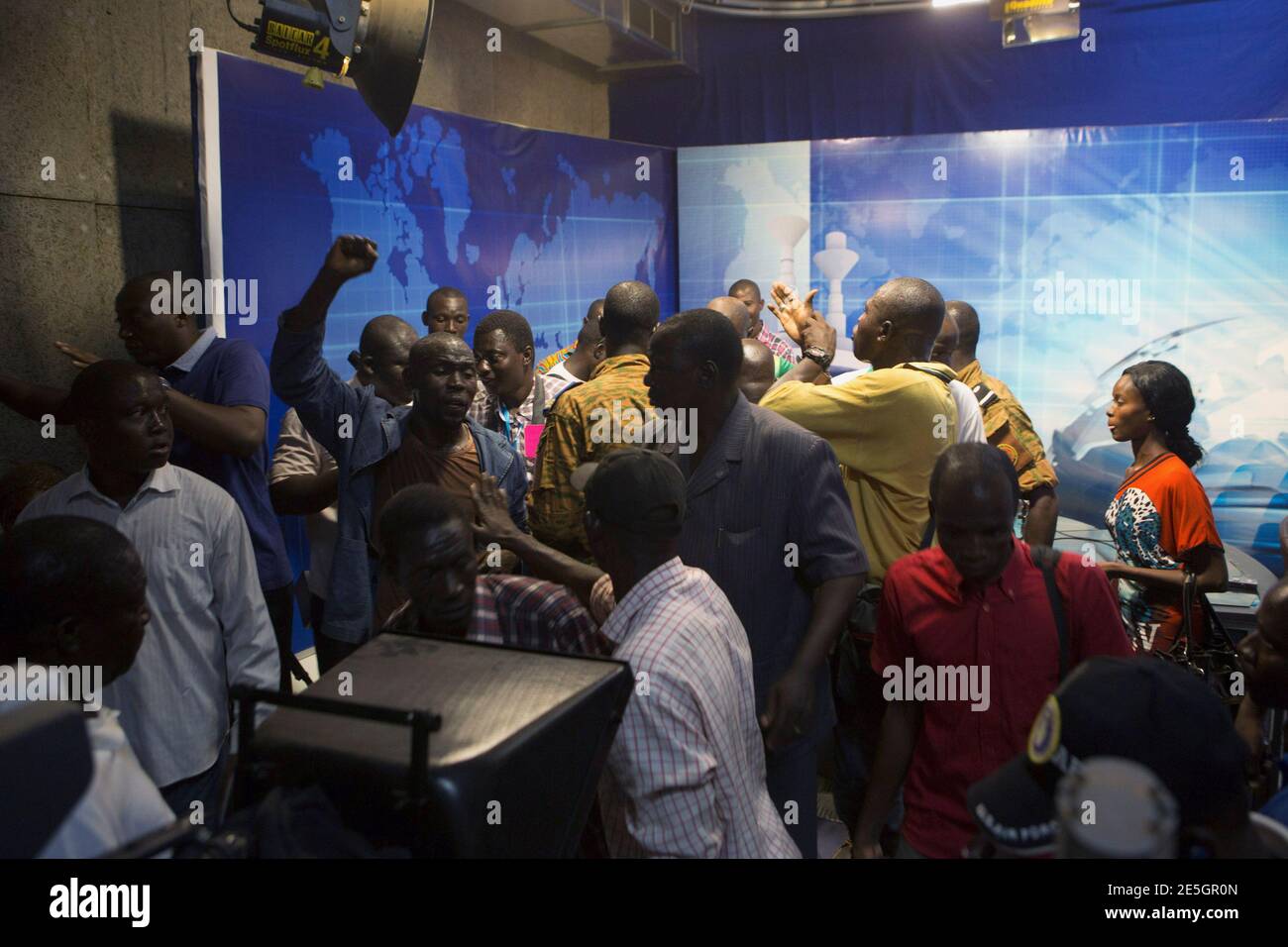 People gather at the podium of the state TV headquarters in Ouagadougou, capital of Burkina Faso, November 2, 2014. Gunfire rang out on Sunday at the headquarters of Burkina Faso's state-run RTB Television as the broadcaster went off air, a Reuters witness said, amid a power struggle following the resignation of long-ruling President Blaise Compaore. The gunshots were fired into the air and there was no immediate sign of injuries. REUTERS/Joe Penney (BURKINA FASO - Tags: POLITICS CIVIL UNREST MEDIA) Stock Photo