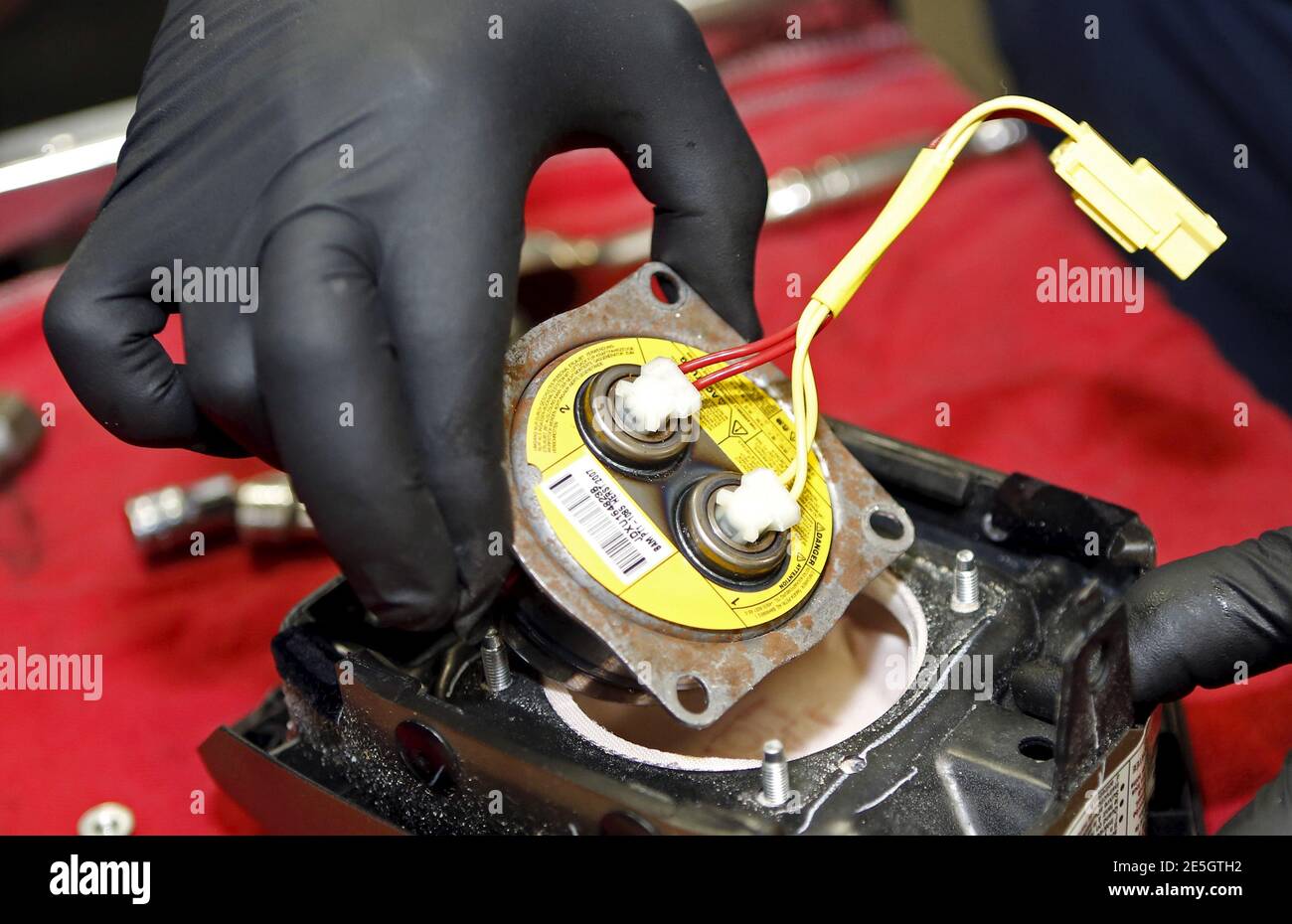 Technician Edward Bonilla holds a recalled Takata airbag inflator after he  removed it from a Honda Pilot at the AutoNation Honda dealership service  department in Miami, Florida June 25, 2015. The head