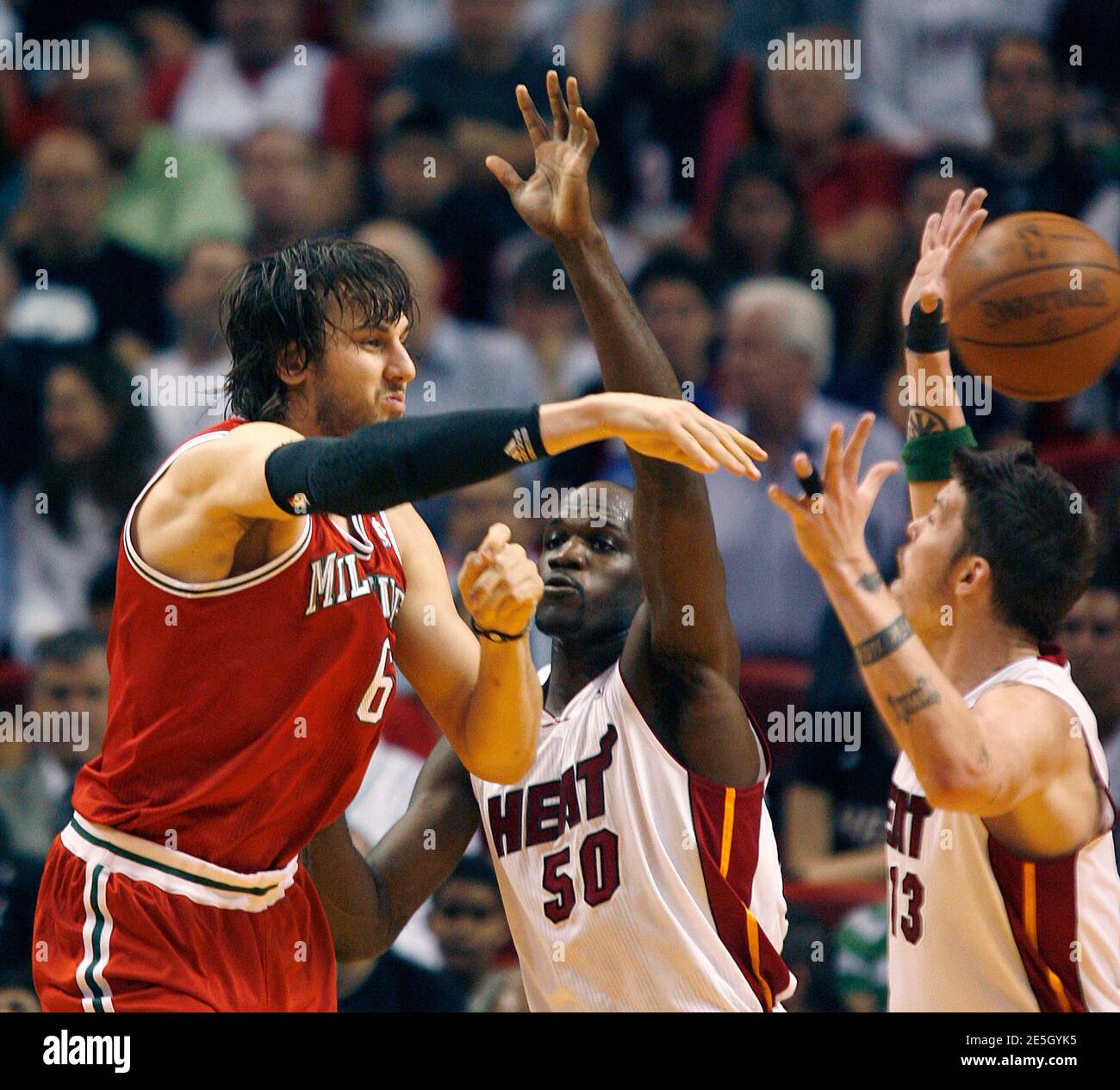 The Milwaukee Bucks center Andrew Bogut (L) passes as Miami Heat center