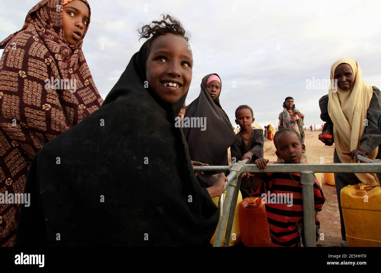 Somali refugee girls collect water from a tank at the Ifo extension refugee camp in Dadaab, near the Kenya-Somalia border, July 31, 2011. The whole of drought- and conflict-wracked southern Somalia is heading into famine as the Horn of Africa food crisis deepens, the United Nations said. REUTERS/Thomas Mukoya (KENYA - Tags: SOCIETY CIVIL UNREST DISASTER ENVIRONMENT) Stock Photo