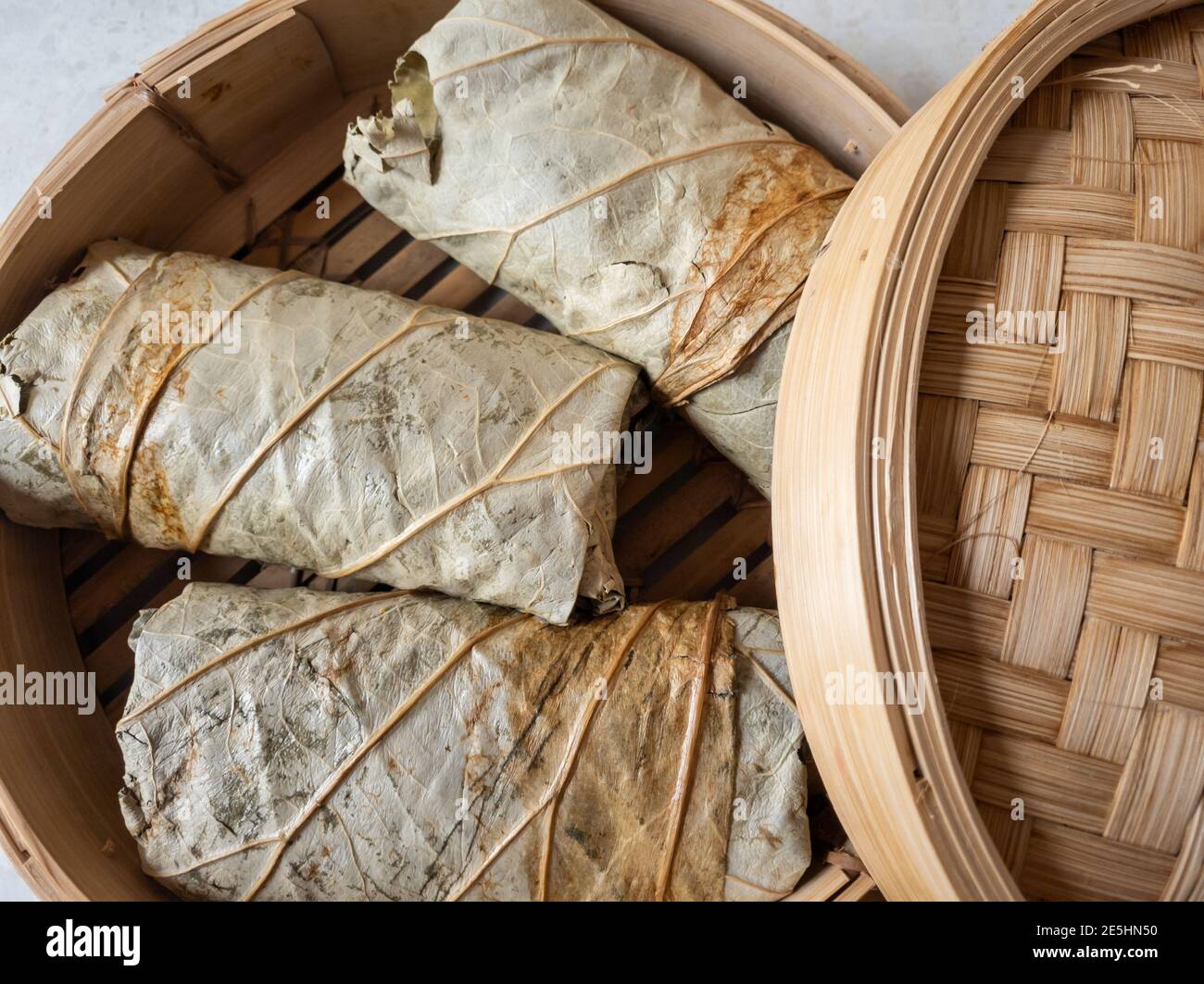 Sticky rice wrapped in lotus leaf ready for steaming. Stock Photo