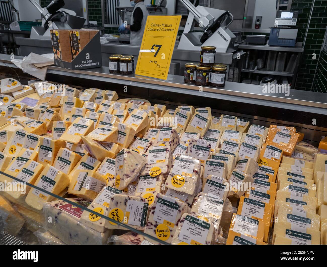 The dairy counter in a supermarket with a selection of cheeses on offer. Stock Photo