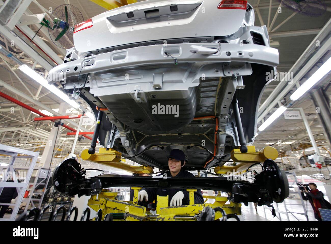 An employee works at the Beiqi E150EV car assembly line of Beijing Electric Vehicle Company, in Beijing November 7, 2012. China's central government will allocate funding to support technological innovation projects such as electric vehicles, plug-in hybrid vehicles and fuel cell vehicles in the nation's new energy auto industry, according to an announcement from the Ministry of Finance. A statement on the ministry's website also said that funds will be used to support the development of new vehicle batteries. REUTERS/Jason Lee (CHINA - Tags: TRANSPORT BUSINESS ENERGY SCIENCE TECHNOLOGY) Stock Photo