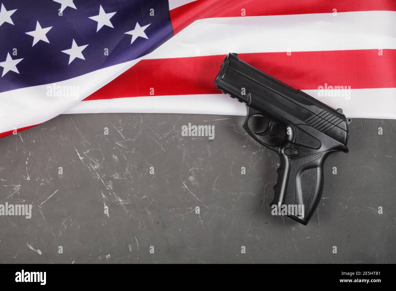 USA flag, pistol on a dark concrete background, place for your text ...