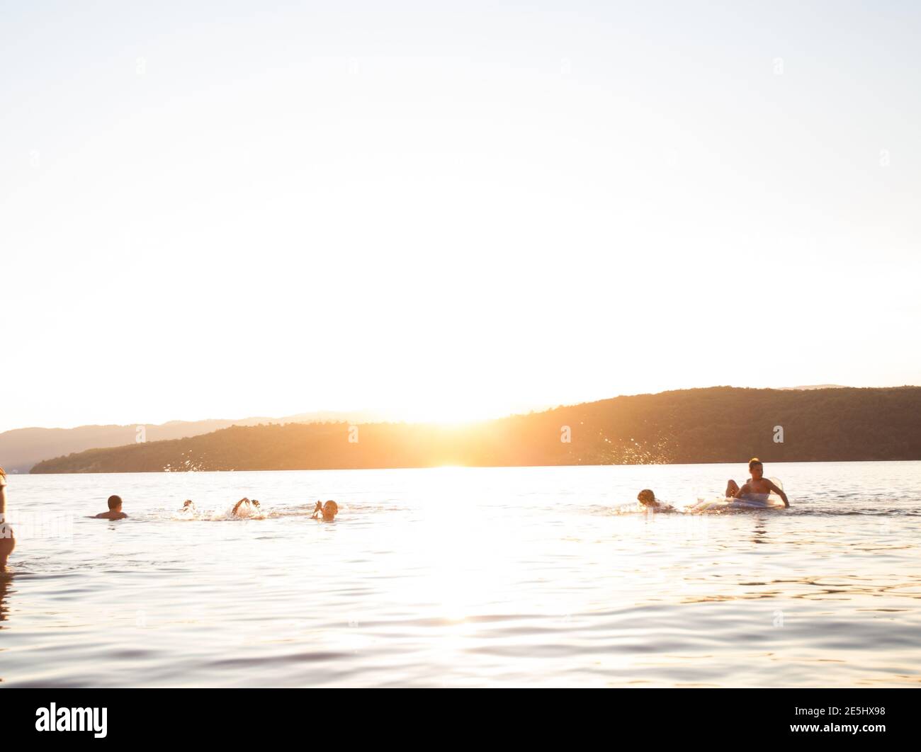 Summer Fun, Friends Enjoy Sunset On The Beach, Splashing In Water Stock Photo