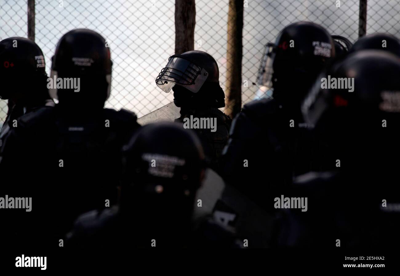 Colombian riot police take a break during protests by students demonstrators in Bogota August 22, 2013. Thousands of demonstrators took part in protests in the country to demonstrate against the government, and to back a strike by farmers who are demanding for financial support from the government. REUTERS/Jose Miguel Gomez  (COLOMBIA - Tags: POLITICS CIVIL UNREST) Stock Photo