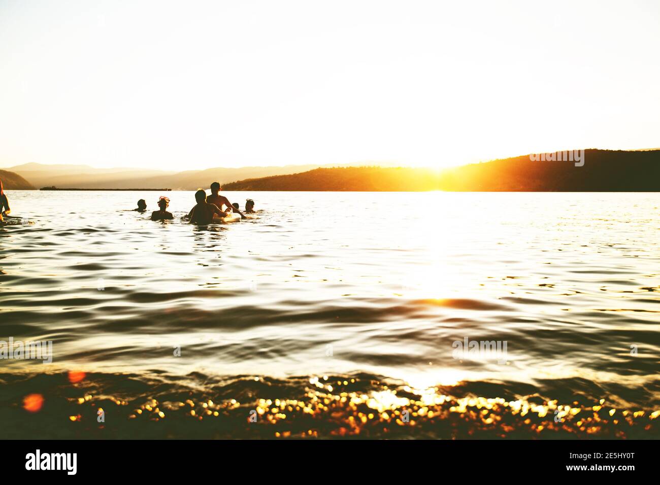 Summer Fun, Friends Enjoy Sunset On The Beach, Splashing In Water Stock Photo