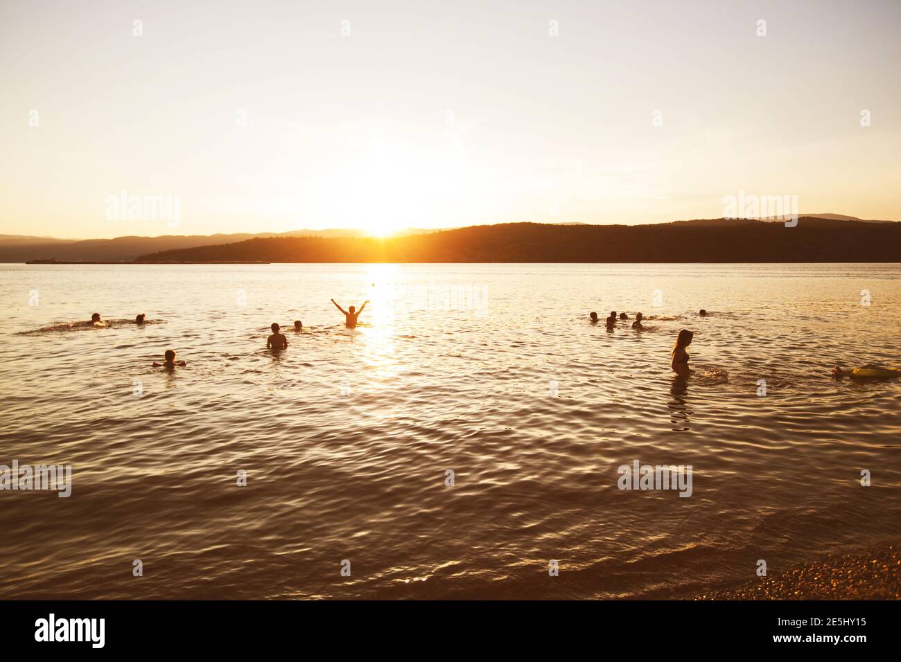 Summer Fun, Friends Enjoy Sunset On The Beach, Splashing In Water Stock Photo