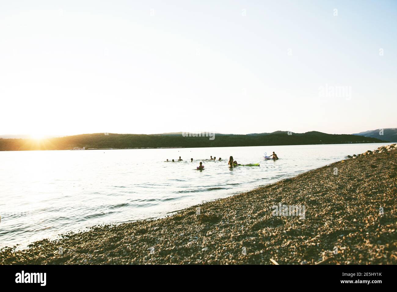 Summer Fun, Friends Enjoy Sunset On The Beach, Splashing In Water Stock Photo