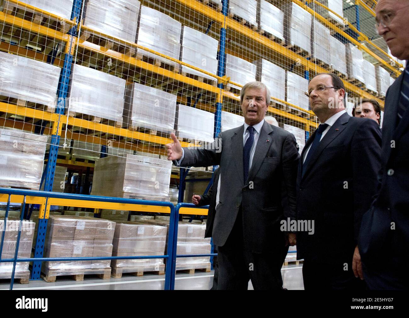 French President Francois Hollande (R) is guided by Vincent Bollore, French  businessman and CEO of investment group Bollore, during a visit of the  Bollore electric battery for cars and buses manufacturing plant,