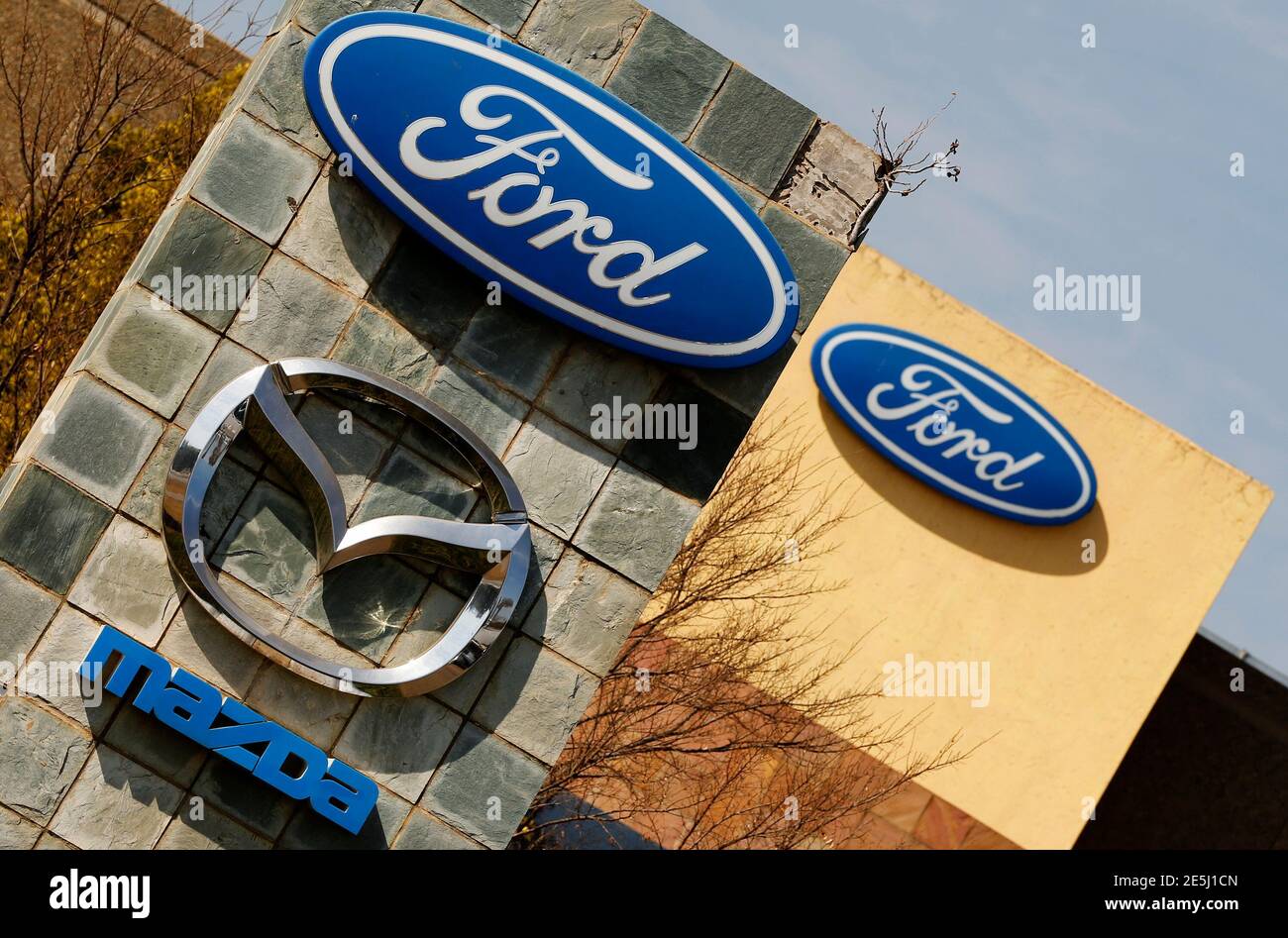 The logos of Ford and Mazda Motor Co are seen at the company's assembly plant in Pretoria July 18, 2014. Ford Motor Co announced 17 new vehicles for Sub-Saharan Africa on Thursday, as carmakers jostle for position in one of the last major markets where potential growth remains largely untapped. The models, among 25 to be introduced by 2016 in a broader product offensive across the Middle East and Africa, draw on the U.S. auto giant's global vehicle architectures to offer more up-to-date features for markets such as South Africa. REUTERS/Siphiwe Sibeko (SOUTH AFRICA - Tags: BUSINESS LOGO TRANSP Stock Photo