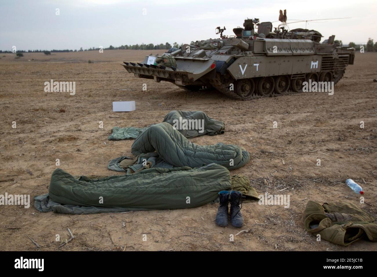 Israeli soldiers sleep in their sleeping bags next to a tank near the  border with the Gaza Strip November 17, 2012. Israeli aircraft pounded  Hamas government buildings in Gaza on Saturday, including