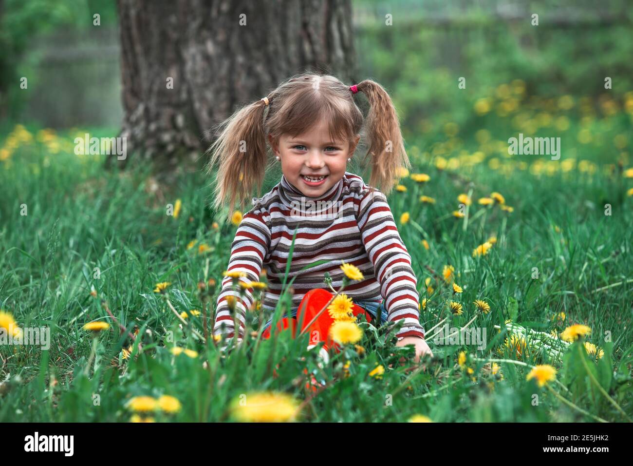 Little girl in the green grass in park Stock Photo - Alamy