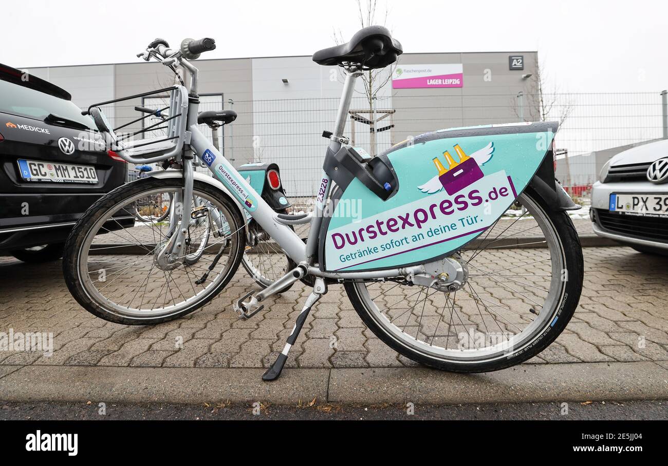 28 January 2021, Saxony, Leipzig: Bicycles with the advertisement of the  beverage delivery service durstexpress.de stand in front of a warehouse of  the company Flaschenpost. On the same day, employees of durstexpress.de