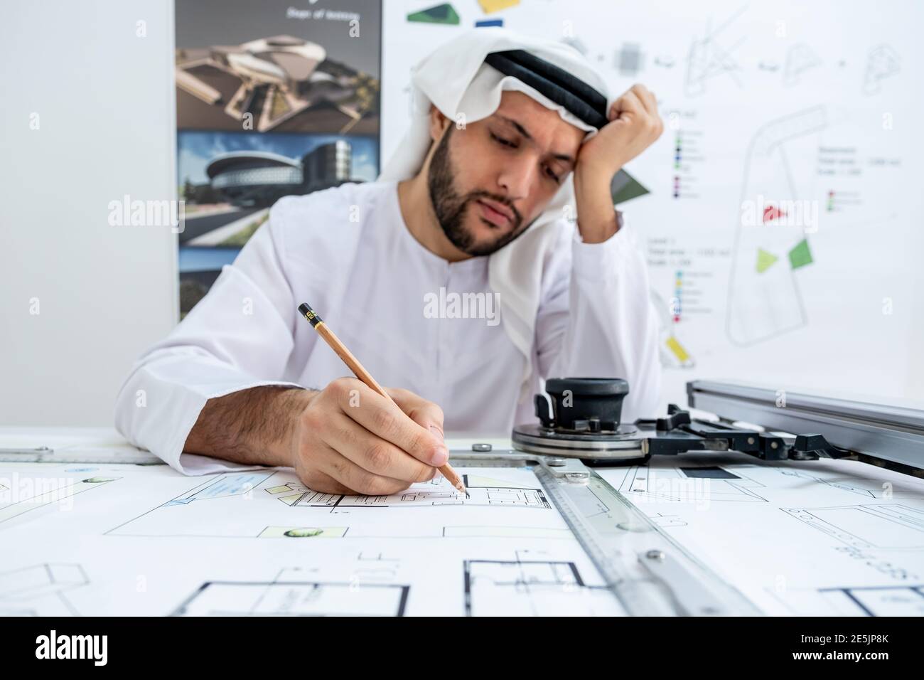Arab male architect working while he is feeling tired Stock Photo