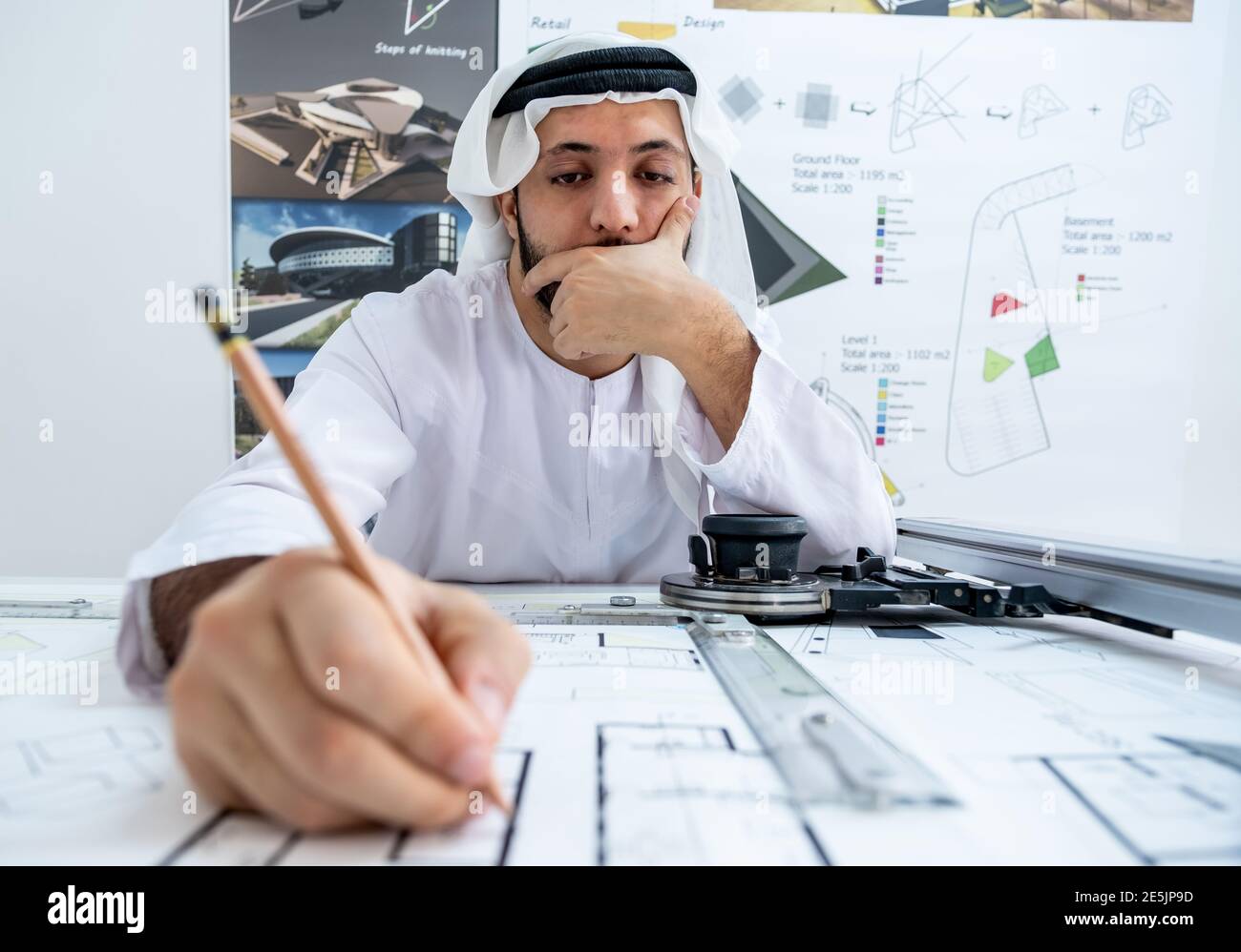 Arab male architect working while he is feeling tired Stock Photo