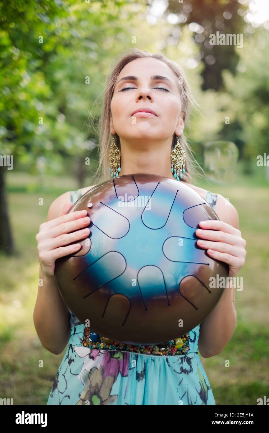 Beautiful hipster woman with authentic alternative drum musical instrument Stock Photo