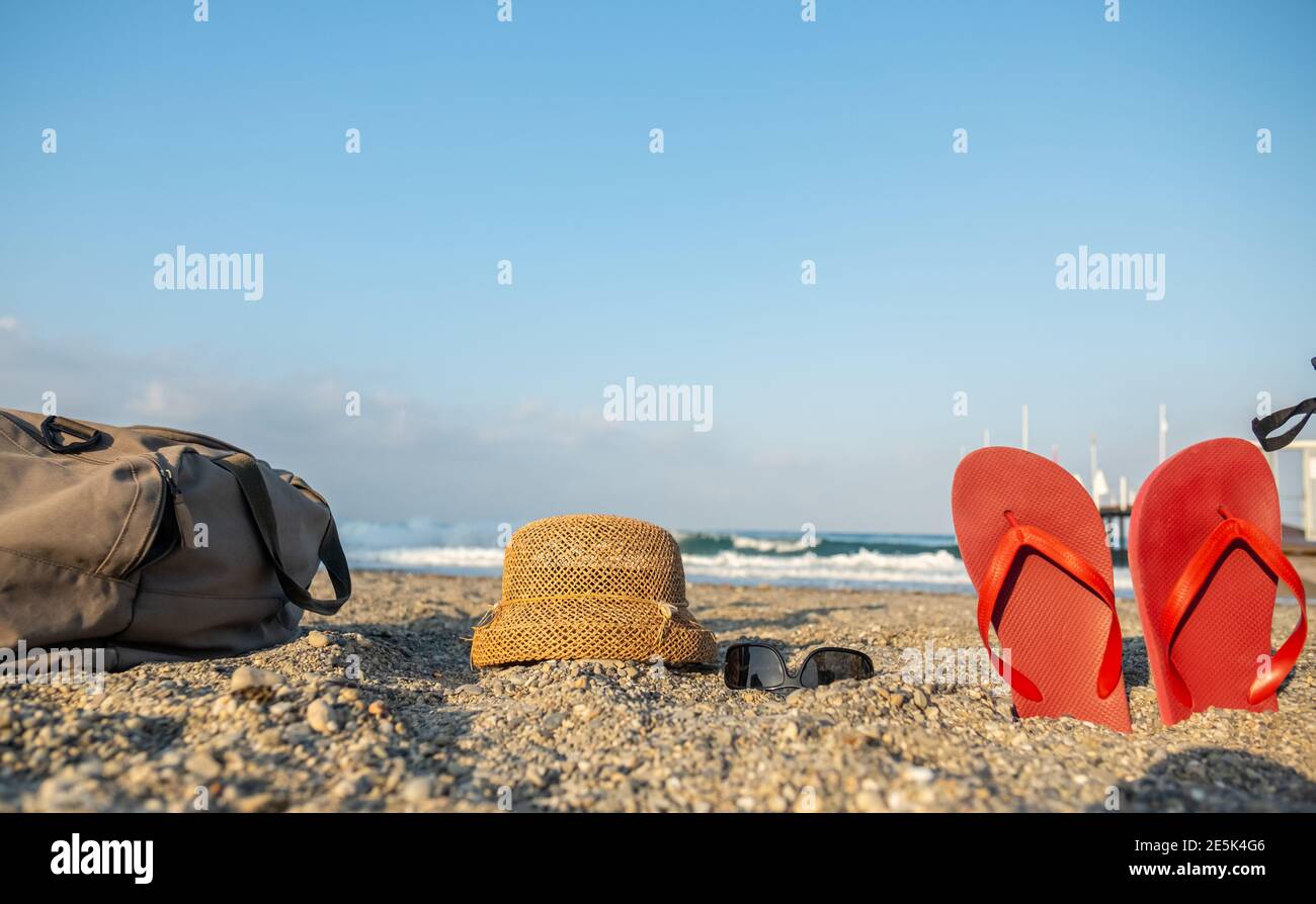 Summer vacation composition. slippers and straw hat on sand Stock Photo ...